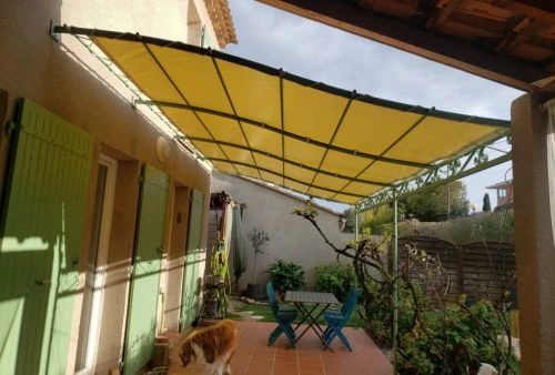 Bâche imperméable beige ivoire installée sur pergola en métal, création d’un espace repas extérieur