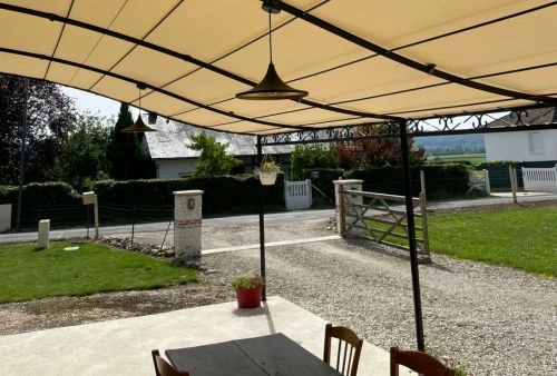 Toile imperméable beige installée sur pergola en fer forgé, aménagement de terrasse extérieure