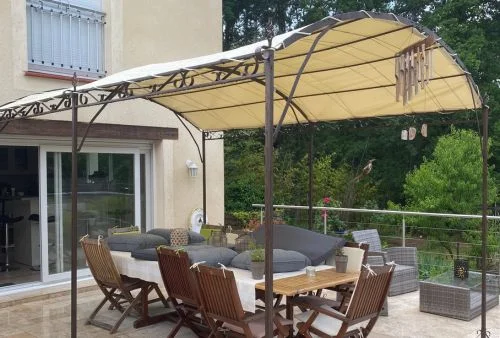 Bâche imperméable beige ivoire sur pergola en fer forgé, protection solaire et pluie pour terrasse