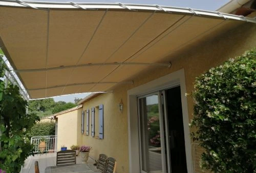 Toile imperméable beige clair Dickson Orchestra sur pergola en métal, aménagement terrasse de maison provençale