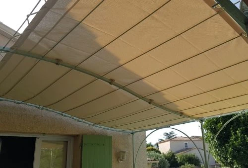 Toile microperforée beige clair pour pergola en fer forgé, ombrage sur terrasse aménagée