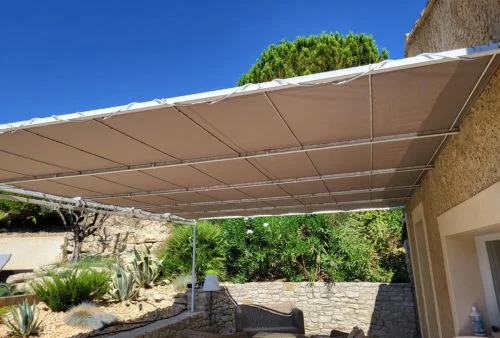 Toile de pergola microperforée beige sable Soltis 96, installée sur structure métallique extérieure
