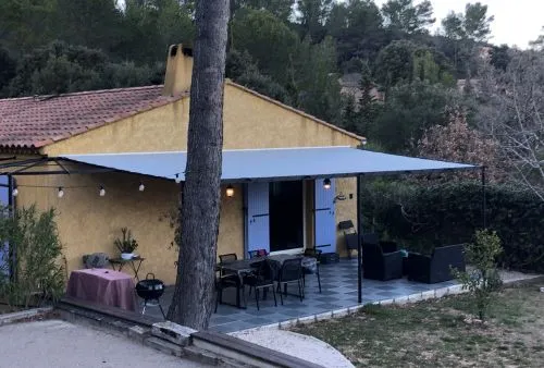 Toile de pergola sur-mesure gris clair pour terrasse de maison provençale, fixation sur structure métallique