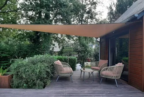 Voile d'ombrage triangulaire beige pour terrasse moderne